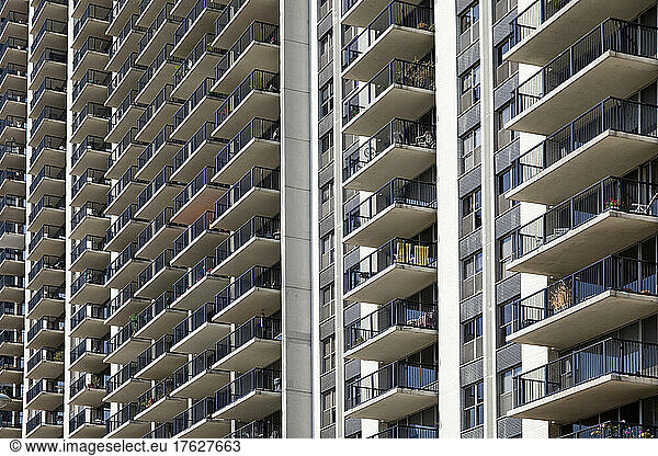 Condominium building exterior  rows of balconies  low angle view.