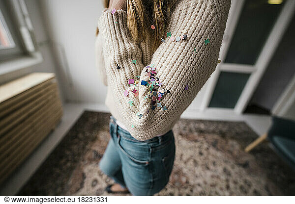 Confetti on woman's arm at home