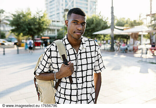 Confidence young african american man looking at camera in city