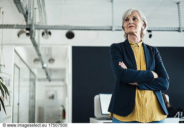 Confident businesswoman with arms crossed at office
