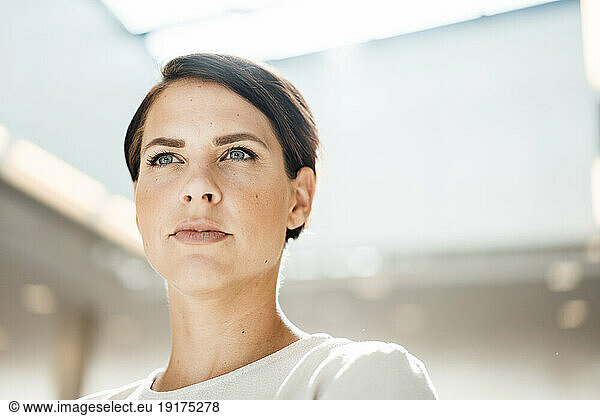 Confident businesswoman with short hair and gray eyes at office