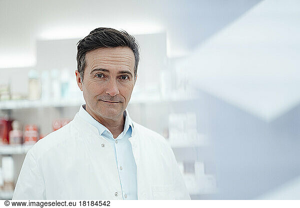 Confident man in lab coat wearing pharmaceutical industry