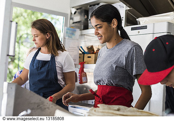 Confident multi-ethnic female colleagues working in food truck