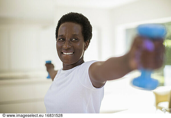 Confident senior woman exercising with dumbbells