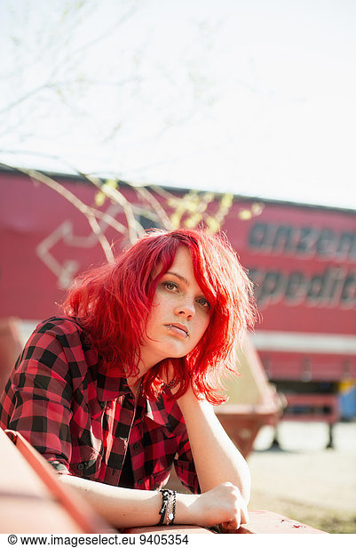 Confident teenage girl piercing bright red hair