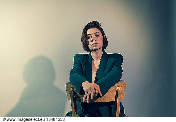 Confident young businesswoman with short hair against white background