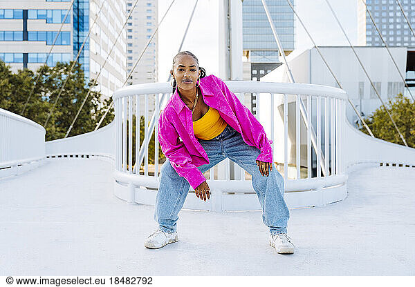 Confident young dancer breakdancing on footbridge