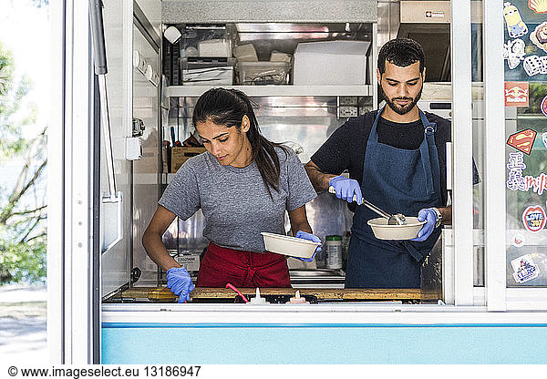 Confident young multi-ethnic male and female colleagues working in food truck
