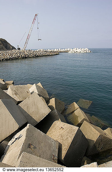 Constructing a new breakwater outside the harbor. Puerto de Vega  Costa Verde  Northern Spain.