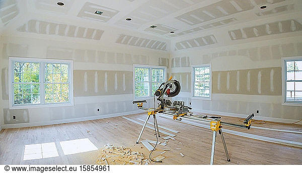 Construction remodeling home cutting wooden trim with circular saw.