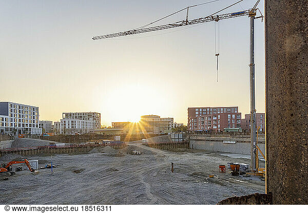 Construction site with buildings and crane at sunset