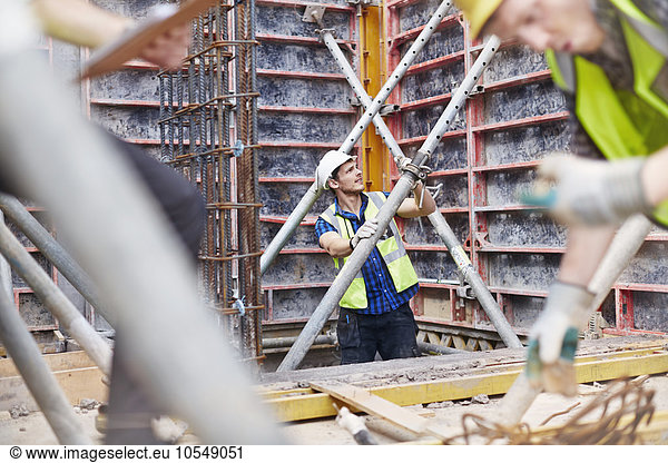 Construction worker examining structure at construction site