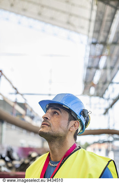 Construction worker looking up at site