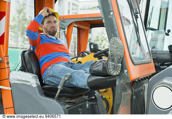 Construction worker sitting in excavator