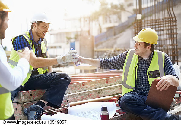 Construction workers and engineer enjoying coffee break at construction site