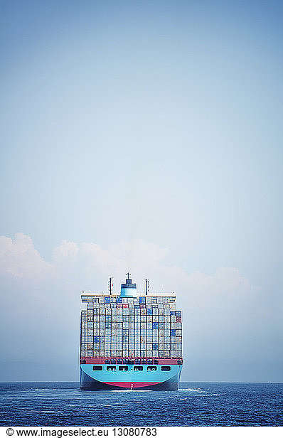 Container ship sailing on sea against sky