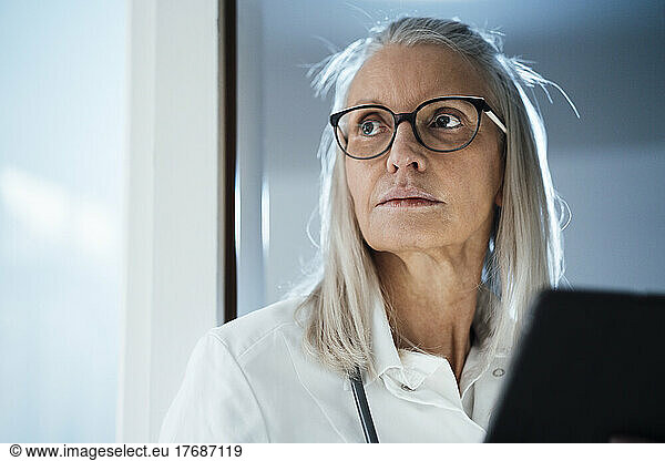 Contemplating female doctor with eyeglasses at hospital
