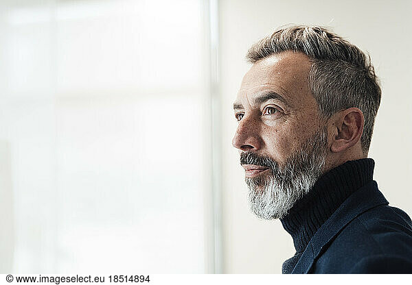 Contemplative businessman wearing turtleneck in office