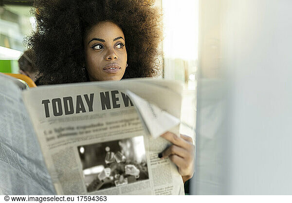Contemplative businesswoman with newspaper in tram