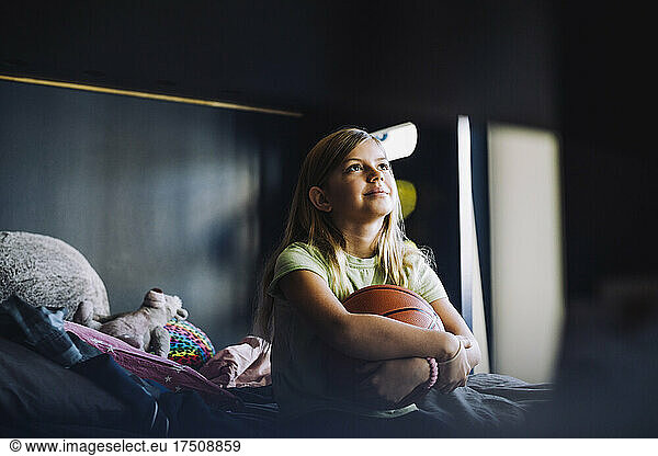 Contemplative girl sitting in bedroom