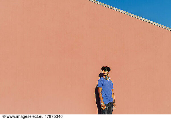 Contemplative man standing in front of wall