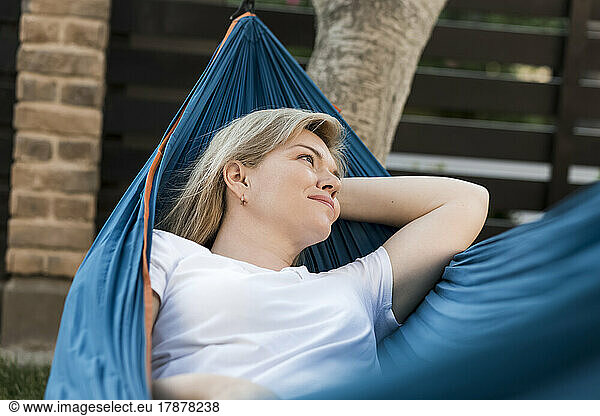 Contemplative mature woman relaxing in hammock