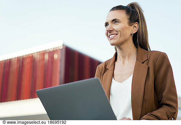 Contemplative young businesswoman with laptop