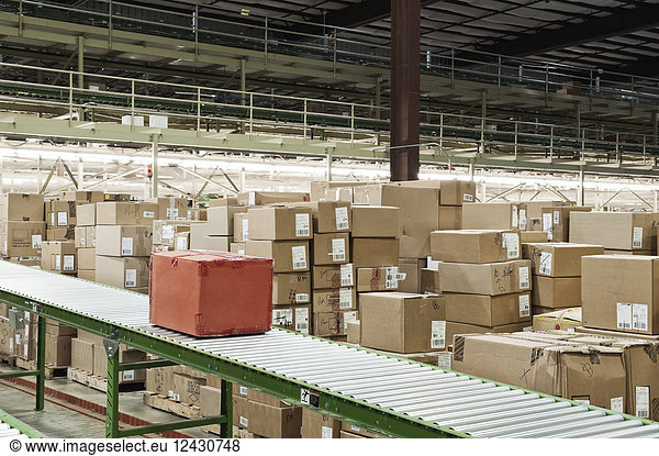 Conveyor belt system and cardboard boxes of products in a distribution warehouse.