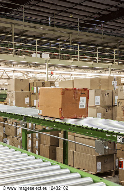 Conveyor belt system and cardboard boxes of products in a distribution warehouse.