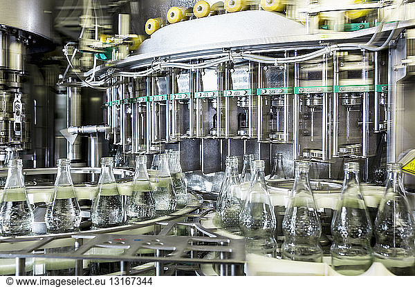 Conveyor belt with bottles of mineral water in factory