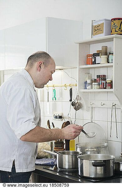 Cook cooking food in pots on stove