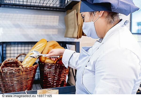 cook in hercook in her restaurant handling the scale restaurant placing bread
