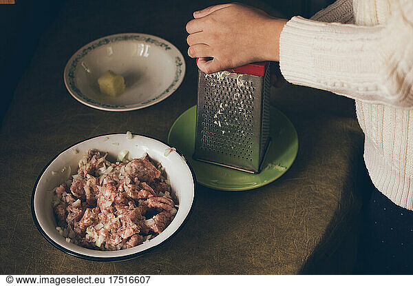 Cooking minced meat. Grating potatoes on grater
