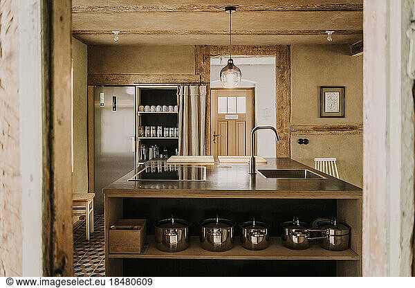 Cooking vessels arranged in shelf on kitchen island