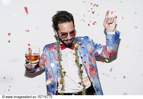 Cool and stylish man wearing a colorful suit and sunglasses dancing at a party
