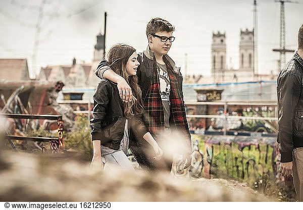 Cooles Teenager-Paar  das in einem alten  heruntergekommenen Industriegebiet spazieren geht
