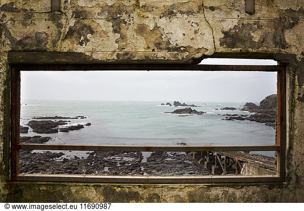 Cornish sea and rocks seen through an old window.