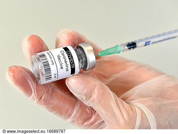 Coronavirus COVID-19-Impfstoff Flasche  Fläschchen  Behälter  in der Hand mit