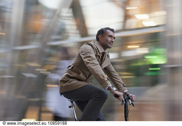 Corporate businessman riding bicycle