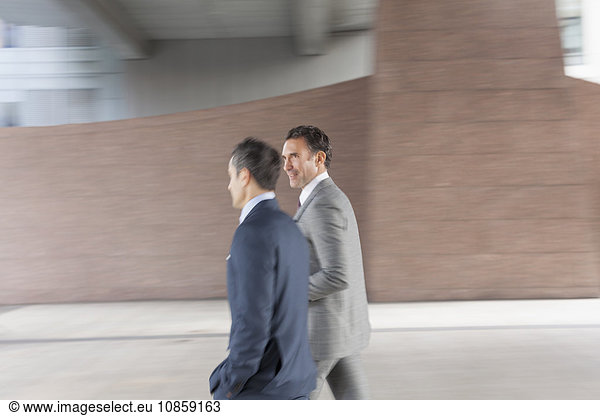 Corporate businessmen walking outside building