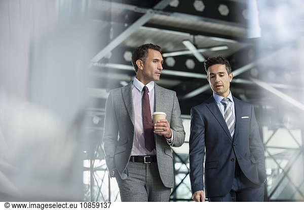 Corporate businessmen walking with coffee
