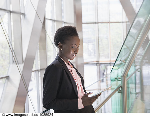Corporate businesswoman using digital tablet in modern office lobby