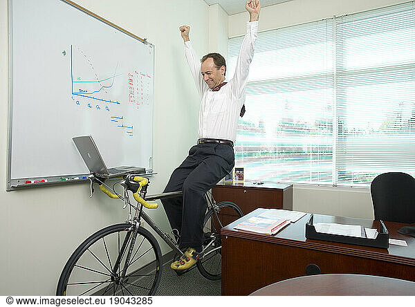 Corporate executive works out on his bicycle trainer as he works in his office in Santa Clara  California.