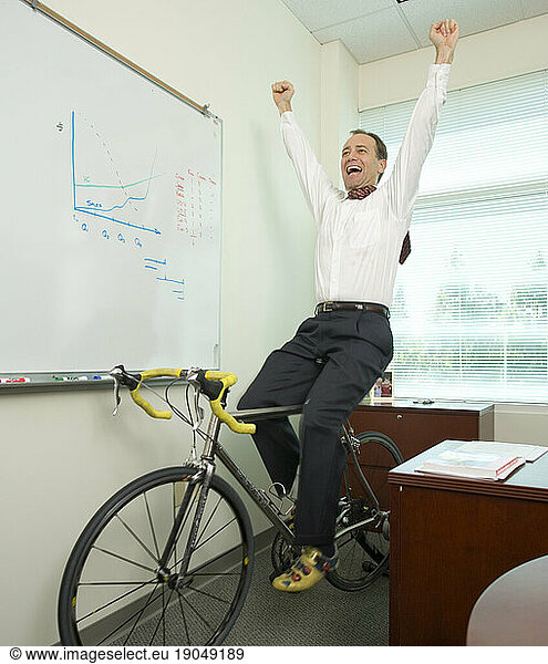 Corporate executive works out on his bicycle trainer as he works in his office in Santa Clara  California.