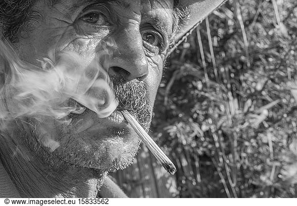 Countryside man smokes handmade cigarette