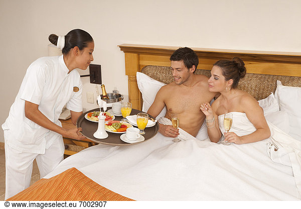 Couple being Served Breakfast in Bed in Hotel