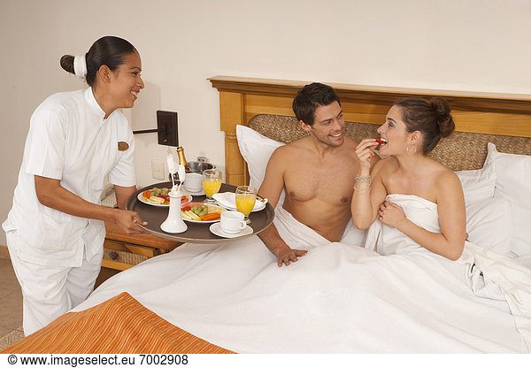 Couple being Served Breakfast in Bed in Hotel