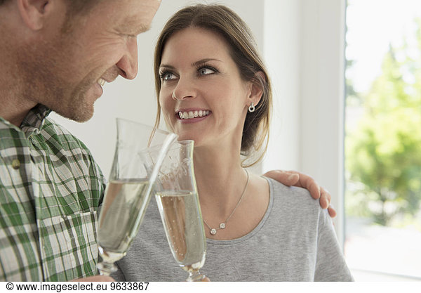 Couple celebrating drinking toasting new home