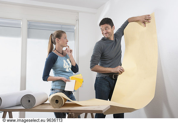 Couple choosing wallpaper for their new home