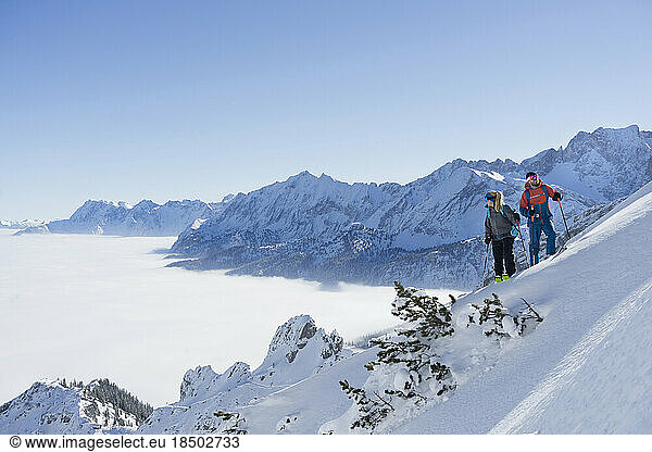 Couple climbing up the ski slope in Upper Bavaria  Germany  Europe
